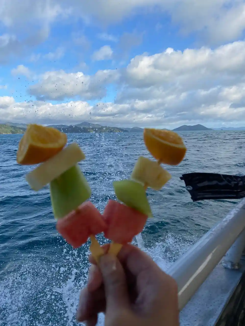 Colorful popsicles held over ocean from boat