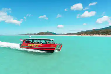 Red speedboat moving through turquoise tropical water