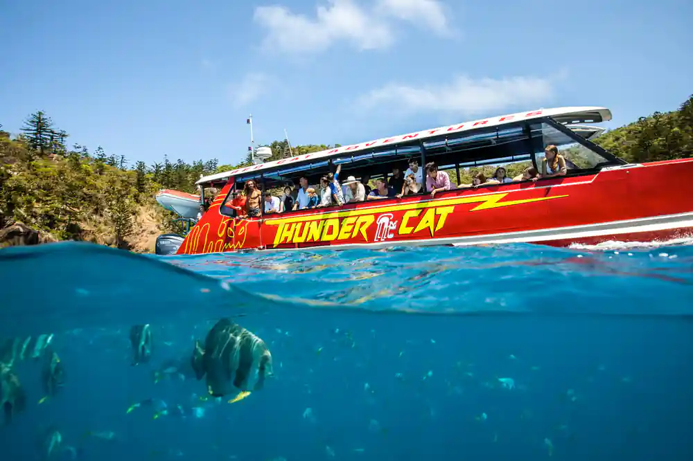 Red speedboat with passengers on tropical water